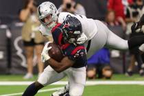 Oakland Raiders defensive end Maxx Crosby (98) grabs the facemask of Houston Texans running bac ...