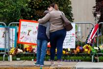 A mother hugs her son in front of a memorial at the Tree of Life synagogue in Pittsburgh on Sun ...