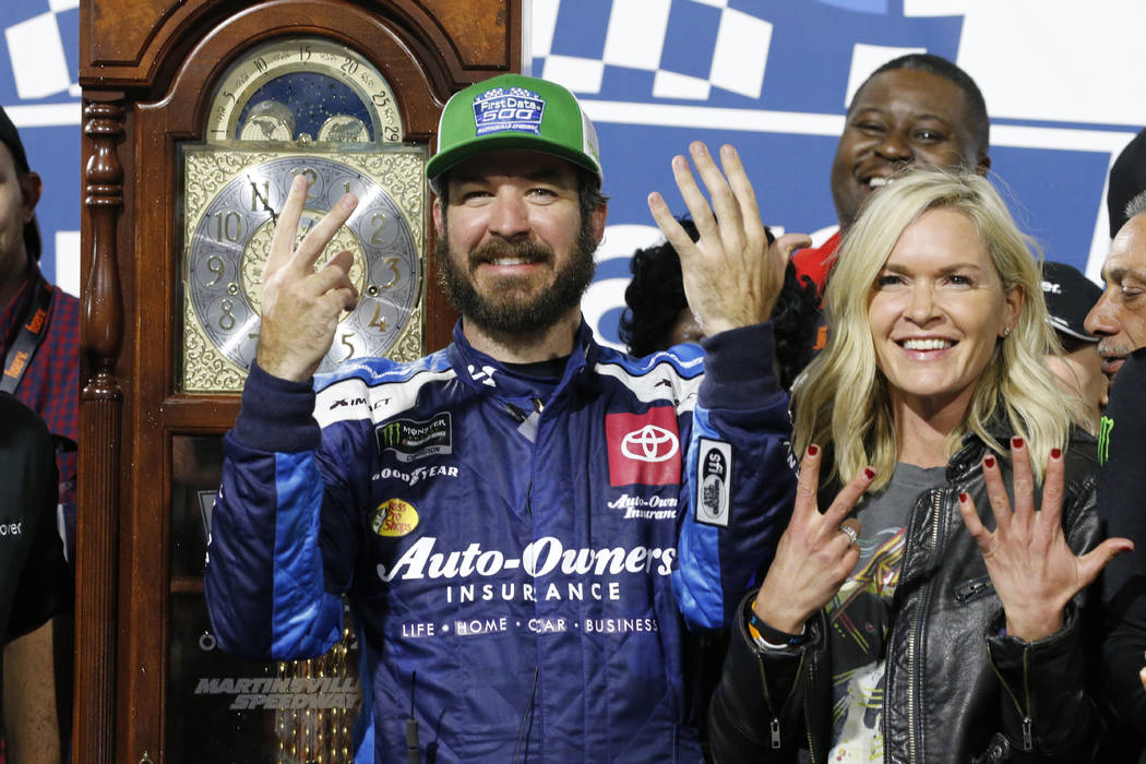 Martin Truex Jr., left, and his girlfriend Sherry Pollex, right, pose with the trophy as he cel ...