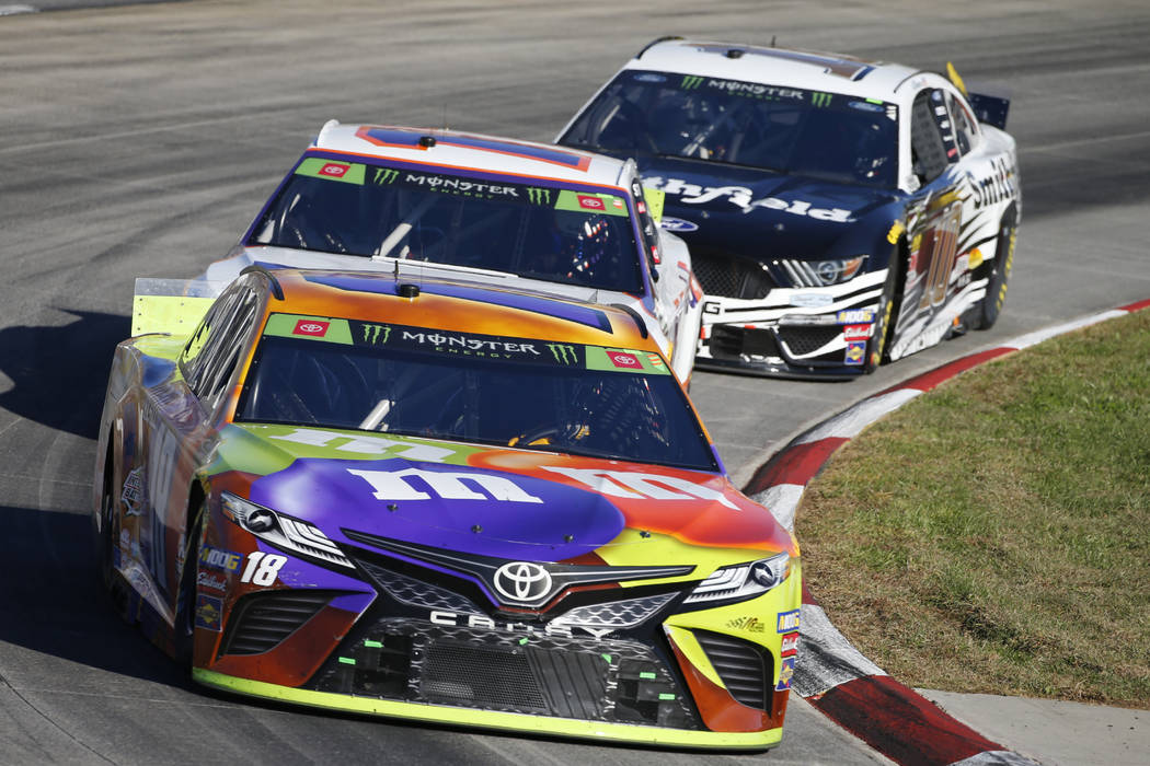 Kyle Busch (18), Denny Hamlin (11) and Aric Almirola (10) compete in the NASCAR Cup Series race ...