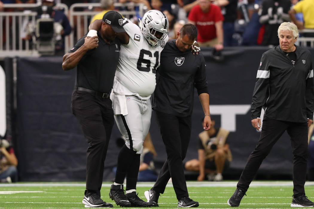 Oakland Raiders center Rodney Hudson (61) is helped off the field his trainers after sustaining ...