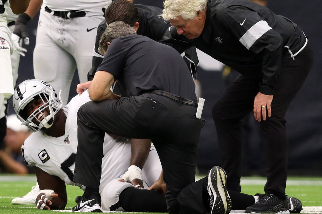 Trainers examine Oakland Raiders center Rodney Hudson (61) after he sustained an injury on a pl ...