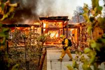 Woodbridge firefighter Joe Zurilgen passes a burning home as the Kincade Fire rages in Healdsbu ...