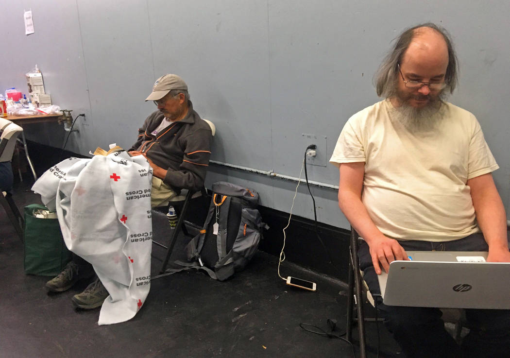 Chris Sherman of Santa Rosa, Calif., right, has his laptop computer plugged in so he can read a ...