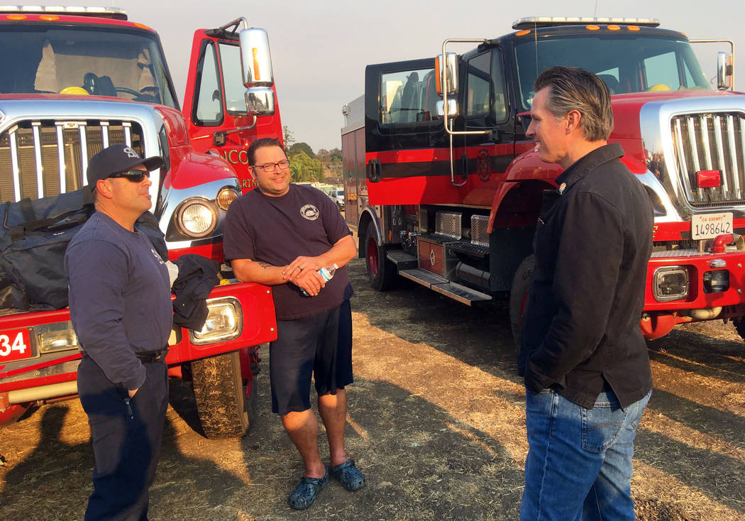 California Gov. Gavin Newsom talks with firefighters Darrin Mayo, left, and Aaron Bjorgum, from ...