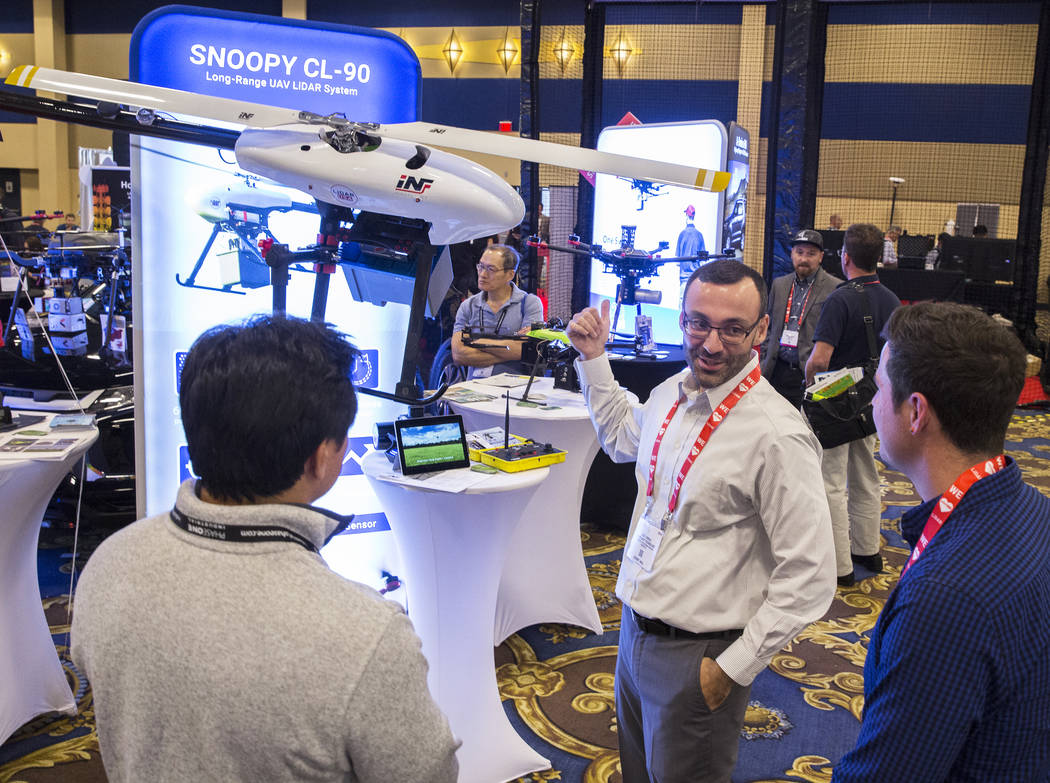 Eric Torres, middle, with Innoflight Technology, discusses the Snoopy CL-90 drone during the Co ...