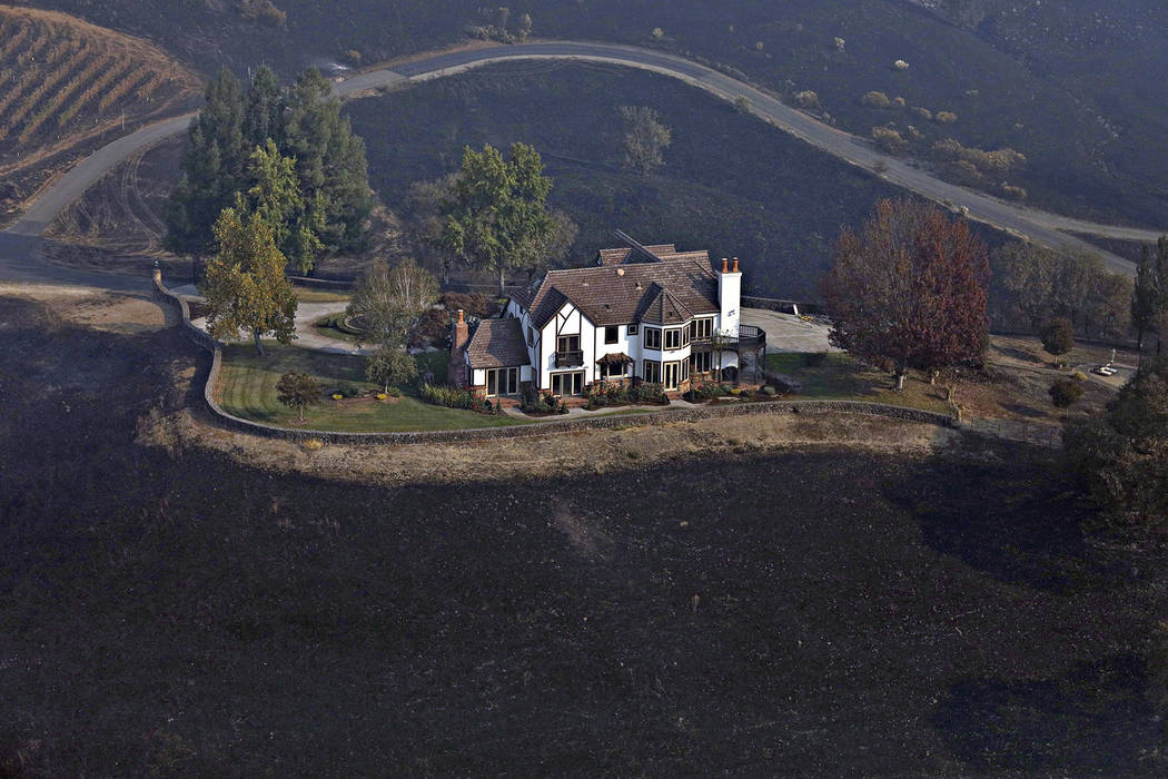 A home between Healdsburg and Windsor, Calif., on Tuesday, Oct. 29, 2019, is surrounded by char ...