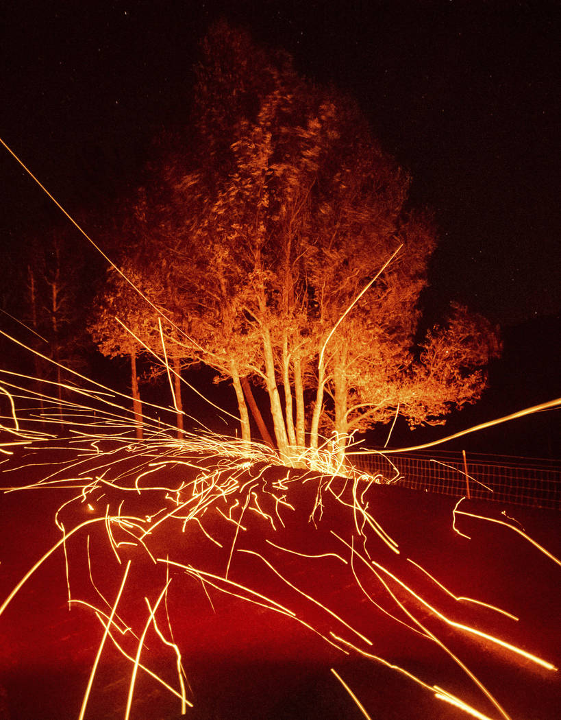 Strong winds send embers flying across Ida Clayton Rd. as the Kincade Fire burns in Calistoga, ...