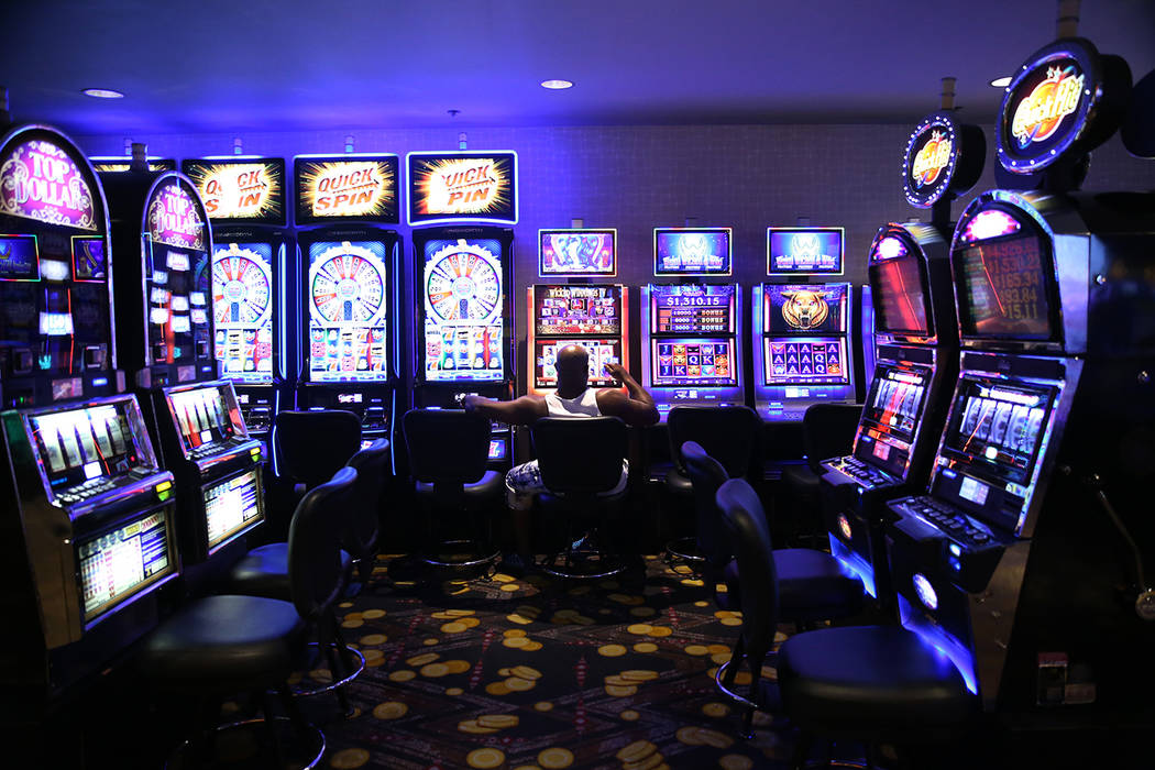 A person sits in front of a slot machine at the D Las Vegas hotel-casino in Las Vegas, Friday, ...