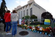 Passersby stop to pay respect outside the Tree of Life synagogue in Pittsburgh on Sunday, Oct. ...