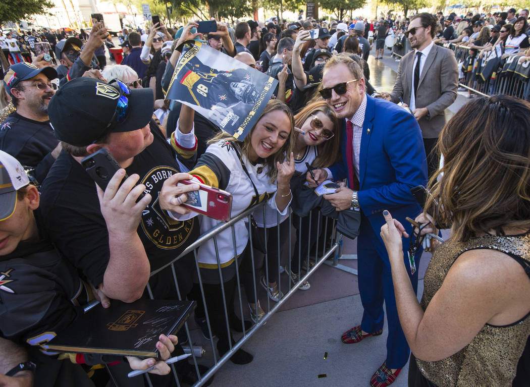 Golden Knights' Nate Schmidt poses for pictures on the gold carpet after arriving for the NHL s ...