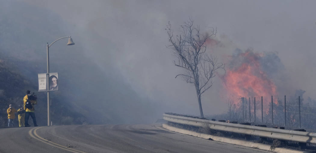 Fire blocks the entrance to the Ronald Reagan Presidential Library in Simi Valley, Calif., on W ...