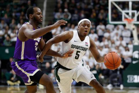 Michigan State guard Cassius Winston (5) drives on Albion forward Quinton Armstrong during the ...