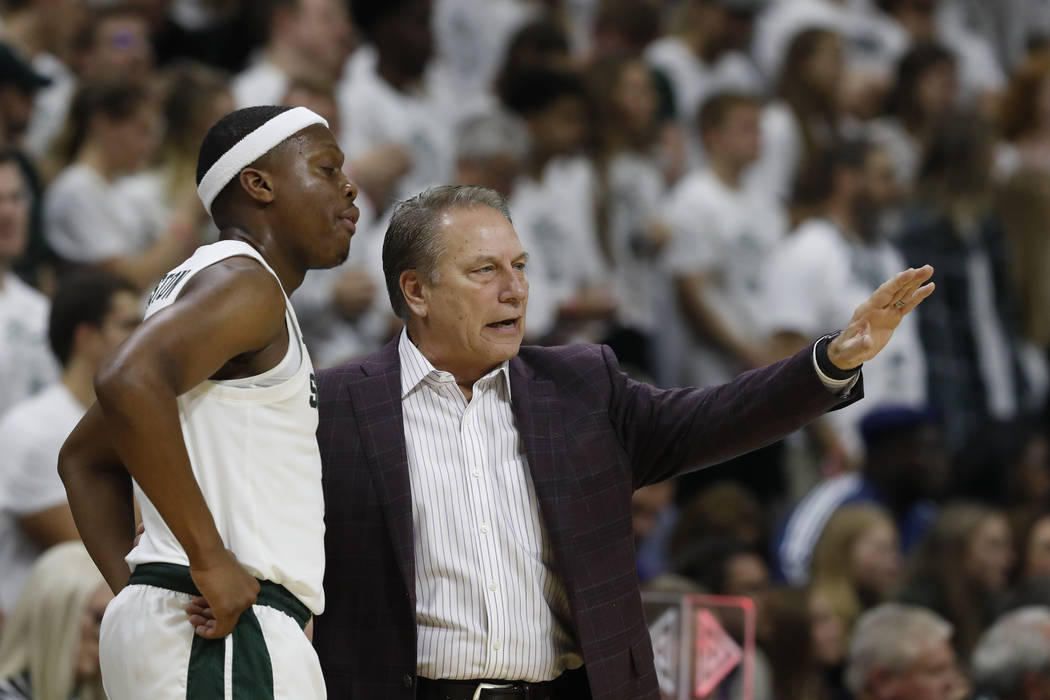 Michigan State head coach Tom Izzo talks with guard Cassius Winston during the first half of an ...