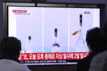 People watch a TV showing file images of North Korea's missile launch during a news program at ...