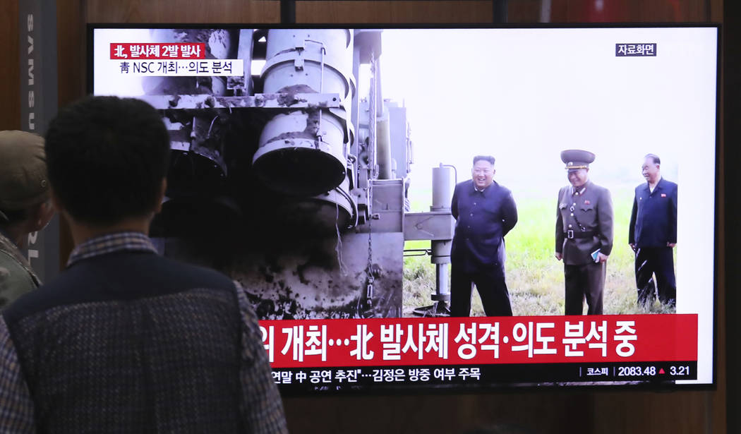People watch a TV showing a file image of North Korean leader Kim Jong Un during a news program ...