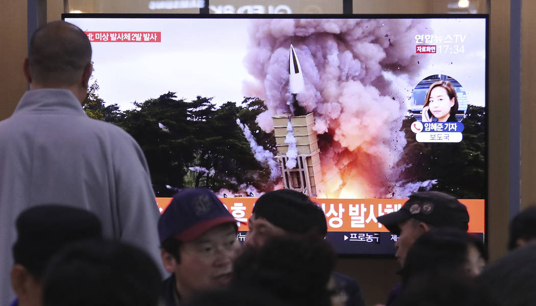 People watch a TV showing a file image of an unspecified North Korea's missile launch during a ...