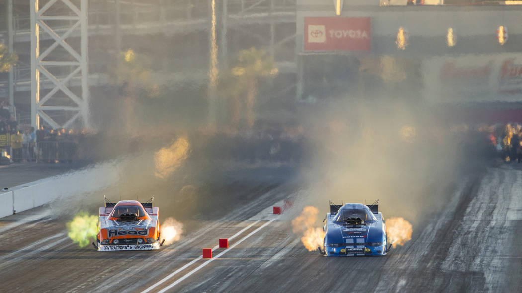 Funny car racers Jonnie Lindberg, left, and Matt Hagan battle in the final round during the Dod ...