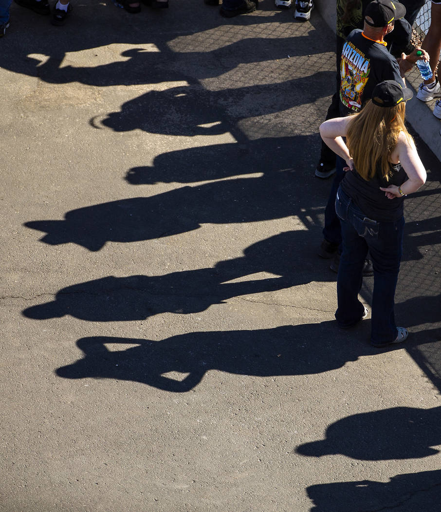 Shadows of fans are reflected on the pavement during the Dodge NHRA Nationals at the Las Vegas ...