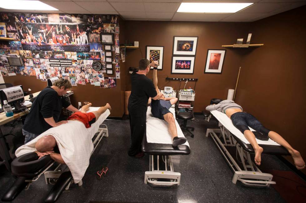 Head of health services Steve McCauley, middle/standing, stretches Brett Hamby before the 7 pm ...