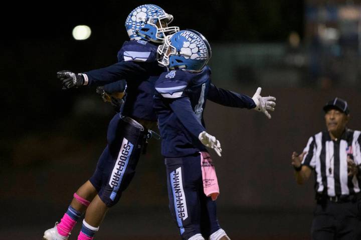 Centennial junior Gerick Robinson (6) celebrates with teammate Aaron Johnson (4) after Robinson ...