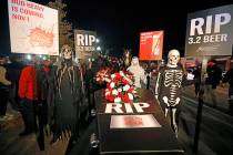 A ghoulish group of pallbearers stand in front of a casket representing 3.2% beer, Wednesday, O ...