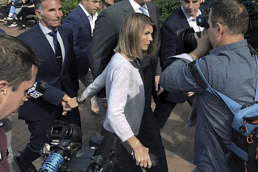 In an Aug. 27, 2019, file photograph, actress Lori Loughlin departs hand in hand with her husba ...