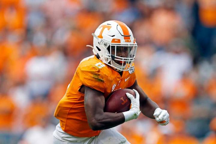 Tennessee running back Ty Chandler (8) runs for yardage in the first half of an NCAA college fo ...