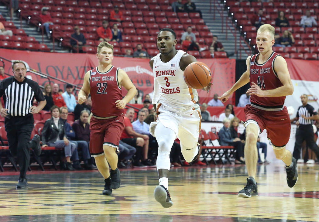 UNLV's Amauri Hardy (3) runs away from West Coast Baptist defenders Seth Hanna (22), left, and ...