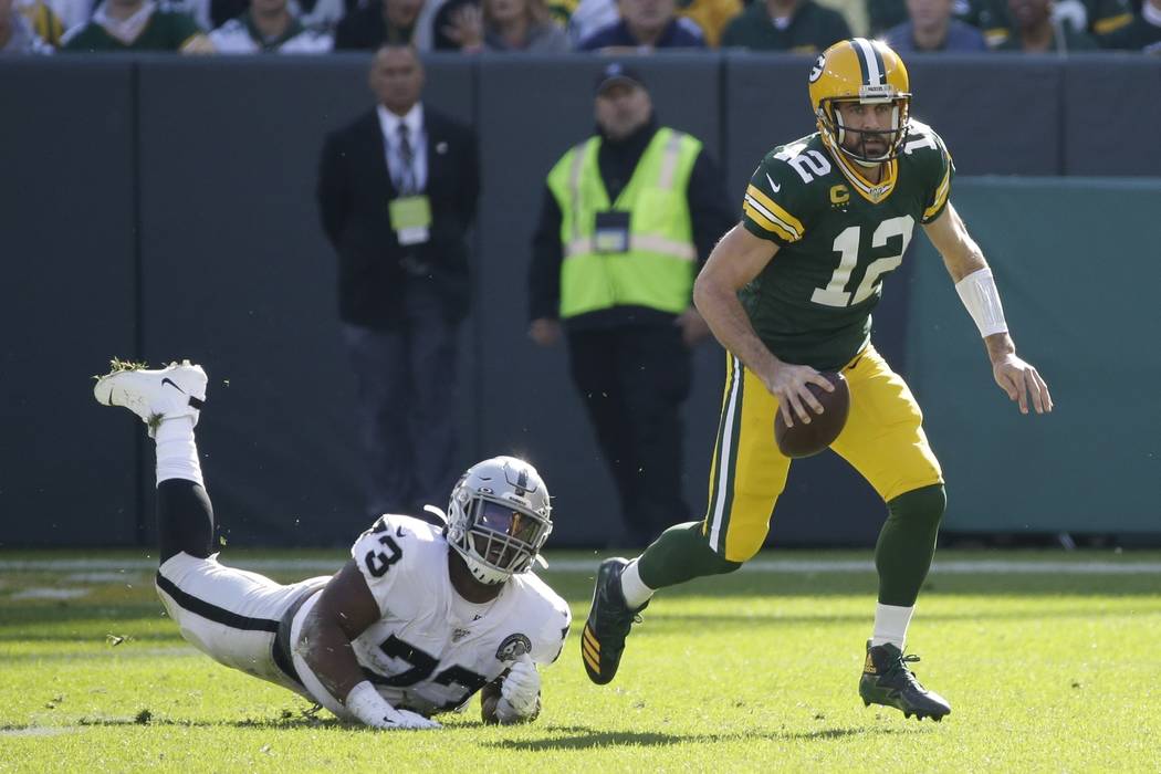 Green Bay Packers' Aaron Rodgers gets away from Oakland Raiders' Maurice Hurst during the first ...
