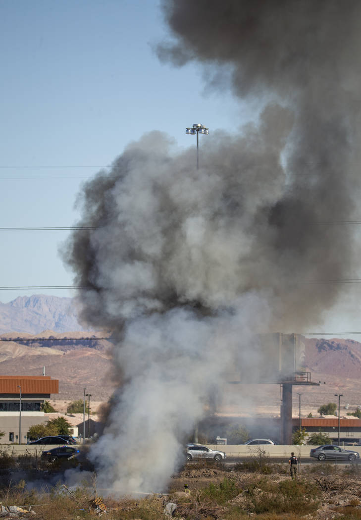 The Henderson Fire Department works a small brush fire just off of the southbound lanes of Inte ...