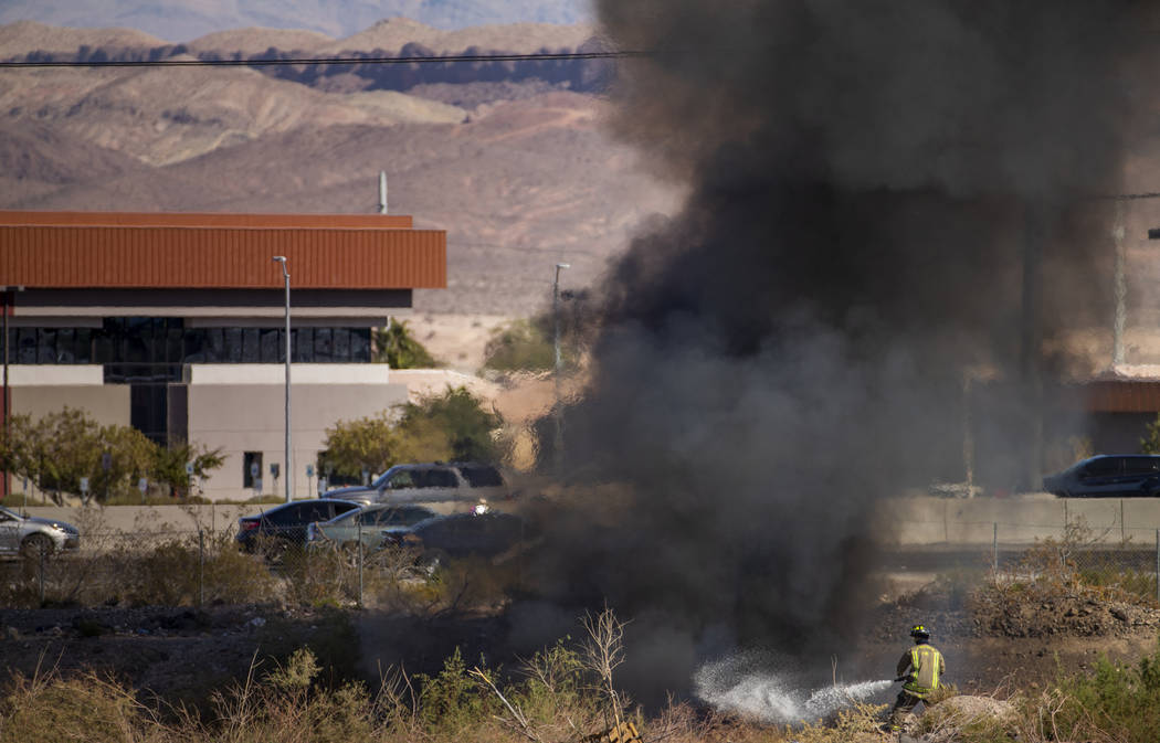 The Henderson Fire Department works a small brush fire just off of the southbound lanes of Inte ...