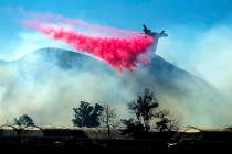 An air tanker drops retardant as the Maria Fire approaches Santa Paula, Calif., on Friday, Nov. ...