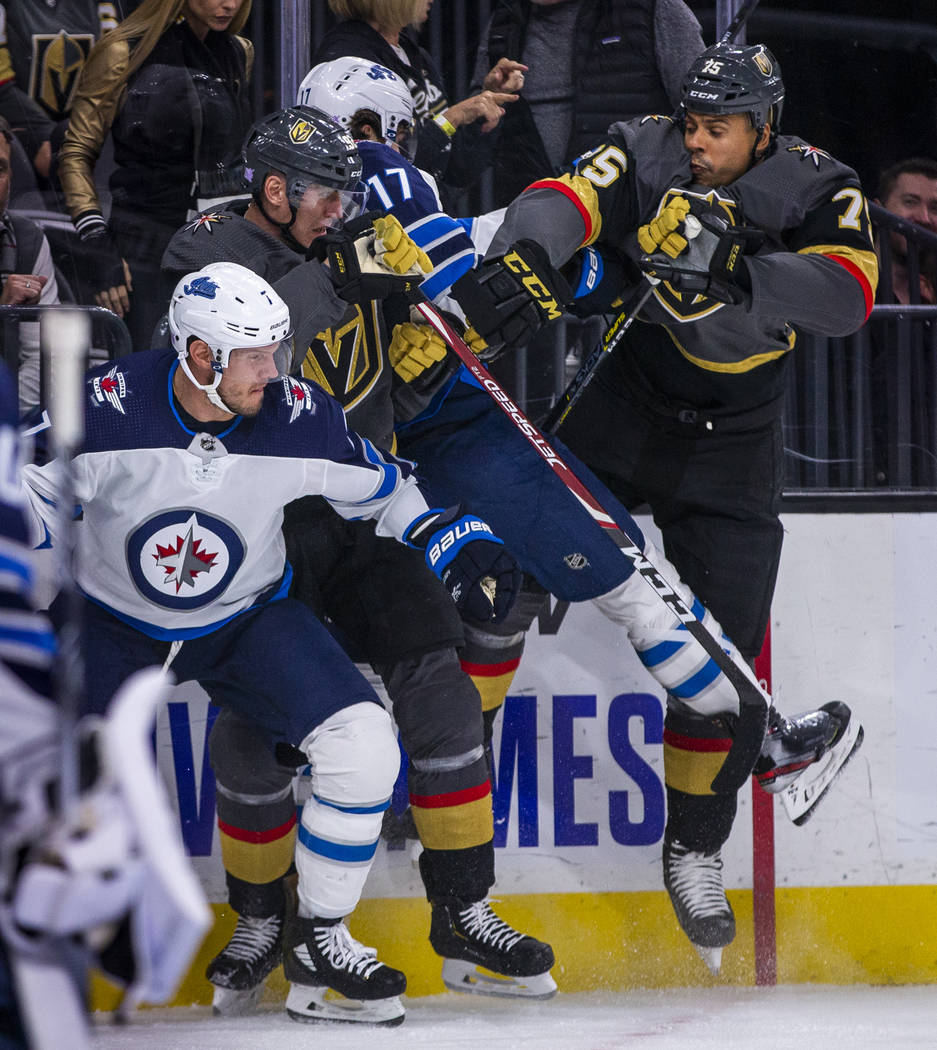 Vegas Golden Knights left wing Tomas Nosek (92) sandwich's Winnipeg Jets left wing Adam Lowry ( ...