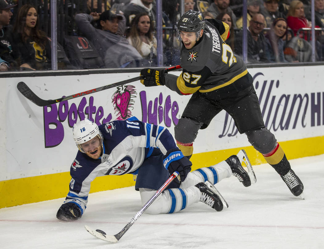 Winnipeg Jets center Bryan Little (18) goes to he ice while battling for the puck with Vegas Go ...