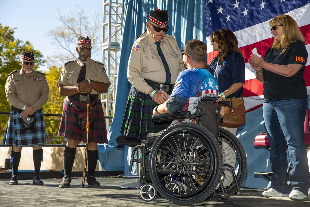 Commander Ed Gilmore, center, with the Scottish-American Military Society Post 711 shakes the h ...