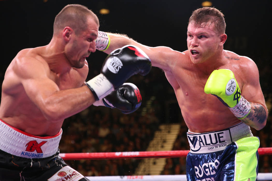 Saul “Canelo” Alvarez, right, throws a punch against Sergey Kovalev during the th ...