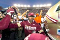 Florida State head coach Willie Taggart, center, tries to separate his team from the Miami team ...