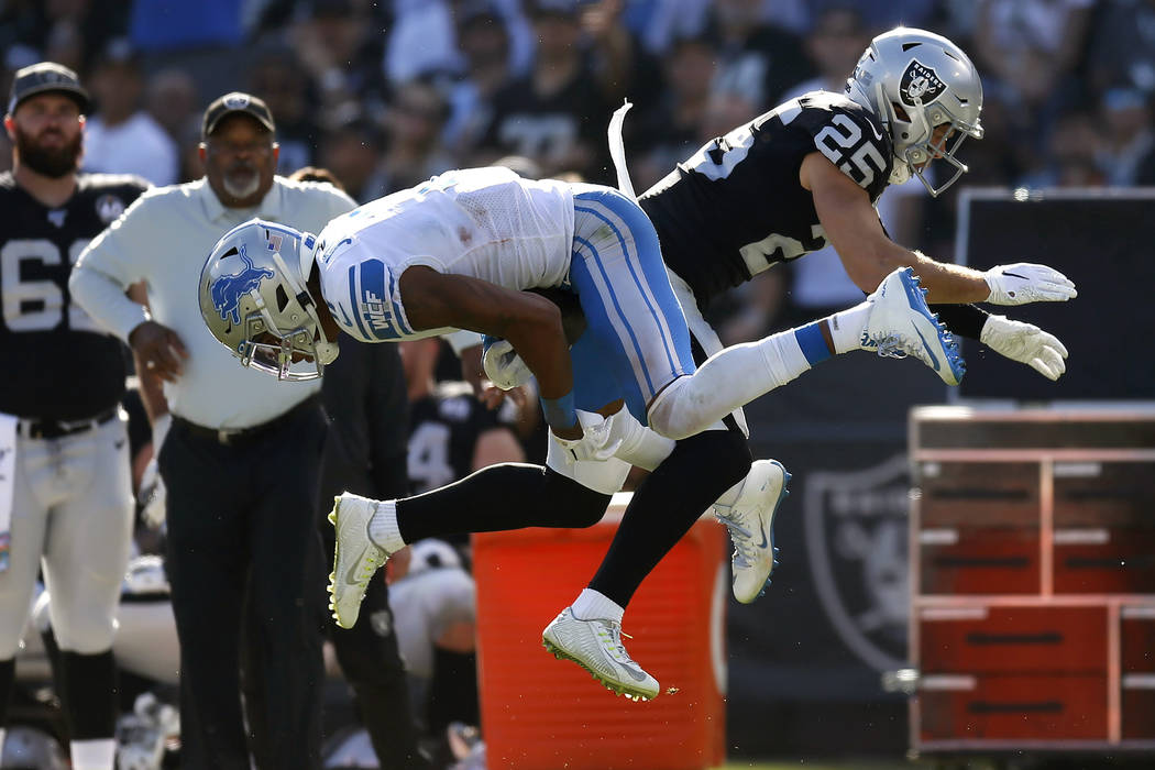 Detroit Lions wide receiver Marvin Jones Jr., left, catches a pass in front of Oakland Raiders ...