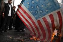 Demonstrators set fire to a rendition of the U.S. flag during a rally in front of the former U. ...