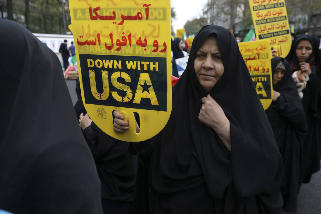 A demonstrator holds an anti-U.S. placard during an annual rally outside the former U.S. Embass ...