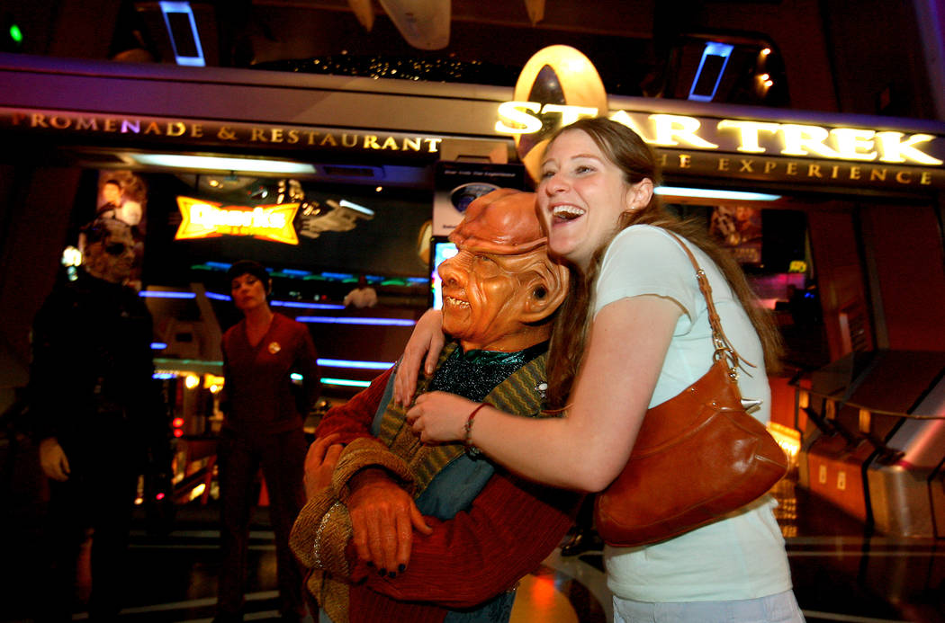 Tracy Jackson of Los Angeles, Calif., hugs an actor dressed as a Ferengi character at the entra ...