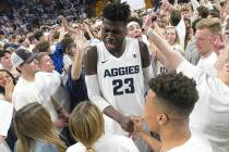 Fans celebrate with Utah State center Neemias Queta (23) on the court after Utah State defeated ...