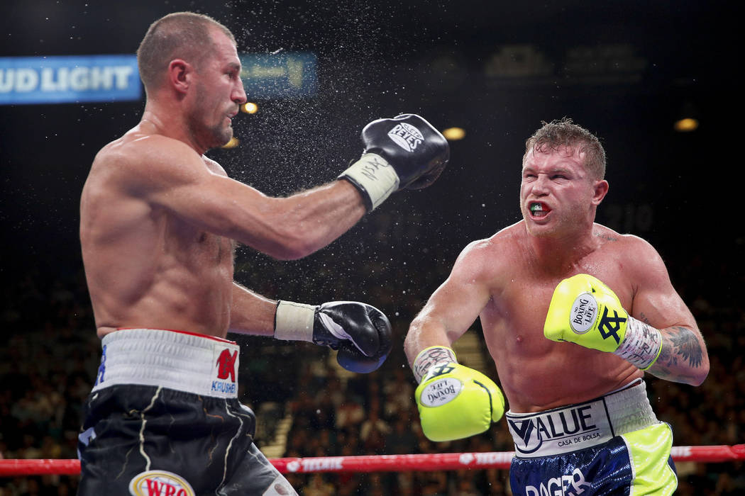 Sergey Kovalev, left, and Canelo Alvarez exchange punches during a light heavyweight WBO title ...
