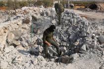 In an Oct. 27, 2019, file photo, people look at a destroyed houses near the village of Barisha, ...