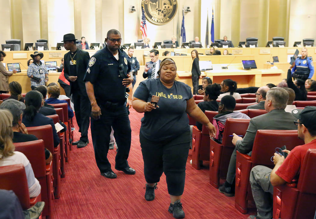 A protester was escorted out of the council meeting where people were protesting against the ci ...