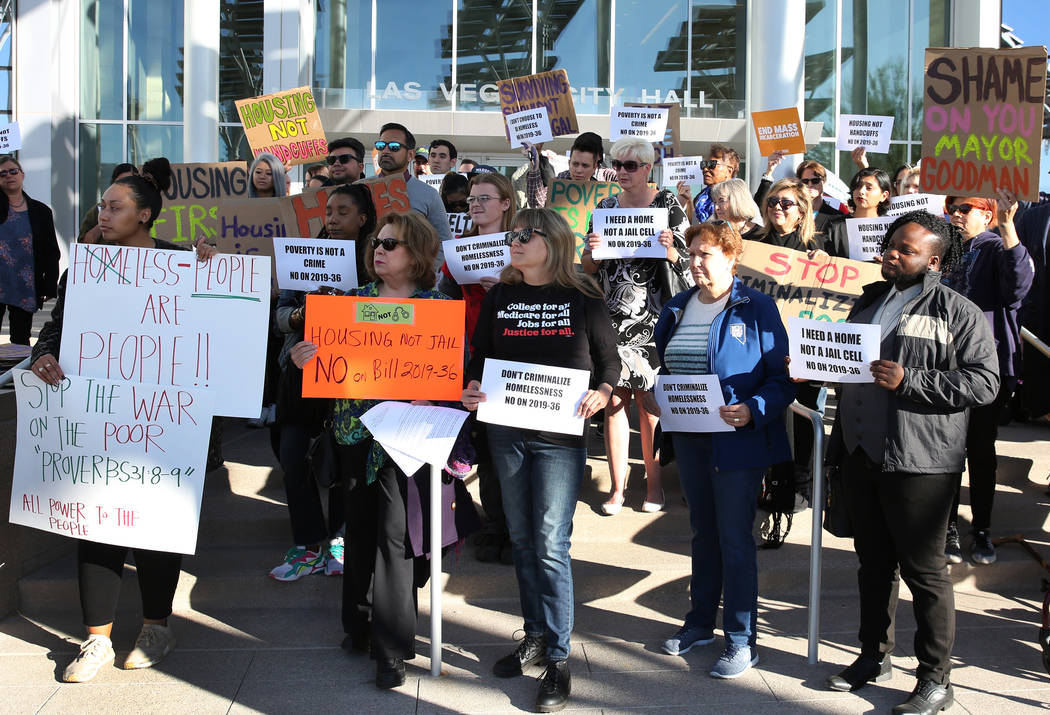 Protesters hold signs outside Las Vegas City Hall during a protest against the city council's c ...
