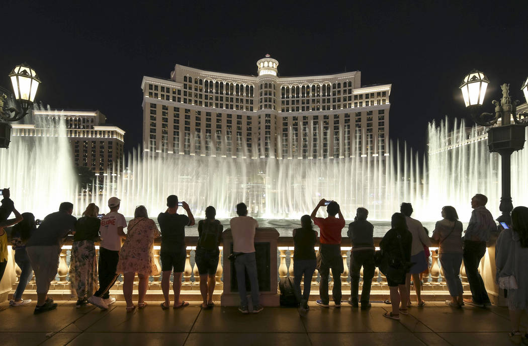 People watch the water fountain show outside the Bellagio hotel and casino on the Strip in Las ...