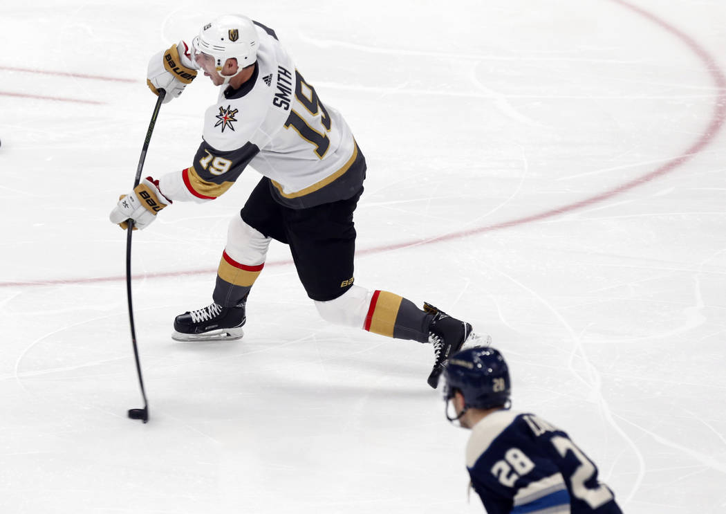 Vegas Golden Knights forward Reilly Smith, left, shoots the puck in front of Columbus Blue Jack ...