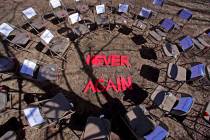 Two rings of chairs encircle the words "NEVER AGAIN" in a silent protest on the 19th anniversar ...